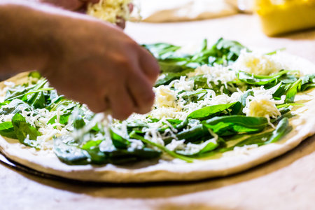 Preparing spinach pizza in Italian restaurant.の写真素材