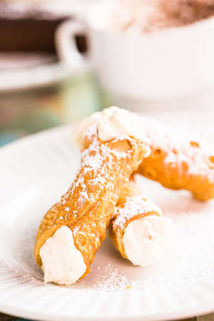 Fresh Italian cannoli with coffee on the table.の写真素材