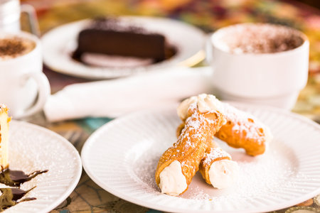 Fresh Italian cannoli with coffee on the table.の写真素材