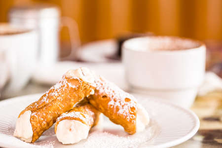 Fresh Italian cannoli with coffee on the table.の写真素材