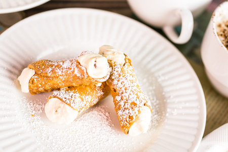 Fresh Italian cannoli with coffee on the table.の写真素材