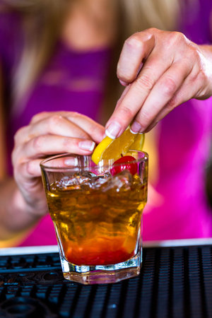 Bartender making new old fashioned cocktail in Italian restaurant.