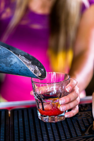 Bartender making new old fashioned cocktail in Italian restaurant.