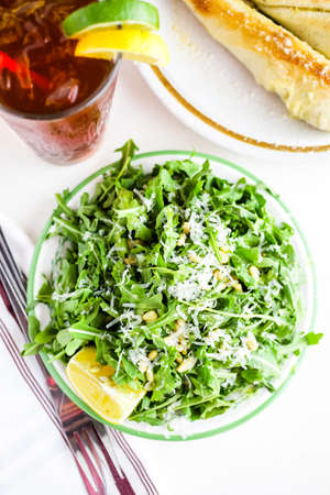 Arugula salad with pine nuts on the plate in Italian restaurant.の写真素材