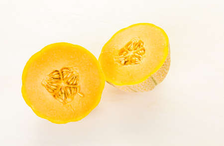 Organic musk melon sliced on white wood board.の写真素材