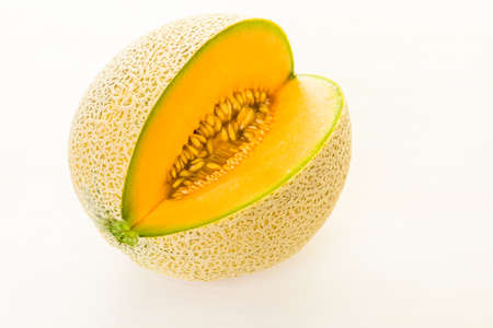 Organic cantaloupe sliced on white wood board.の写真素材
