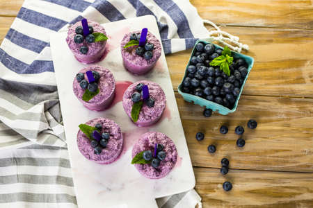 Homemade blueberry popsicles made in plastic cups.の写真素材