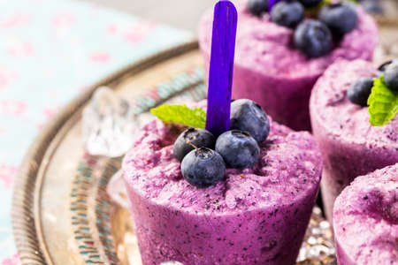 Homemade blueberry popsicles made in plastic cups.の写真素材