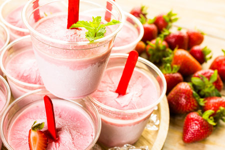 Homemade strawberry popsicles made in plastic cups.の写真素材