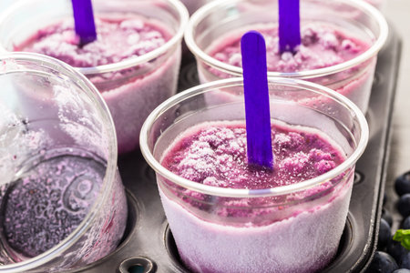 Homemade fruit popsicle made in plastic cups.の写真素材