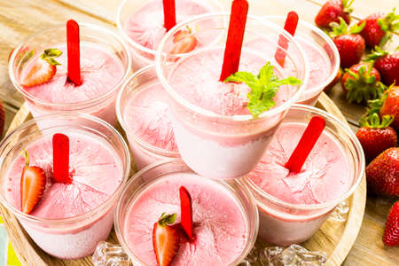 Homemade strawberry popsicles made in plastic cups.の写真素材