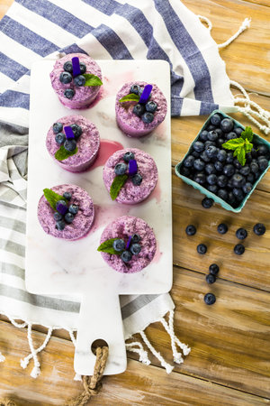 Homemade blueberry popsicles made in plastic cups.の写真素材
