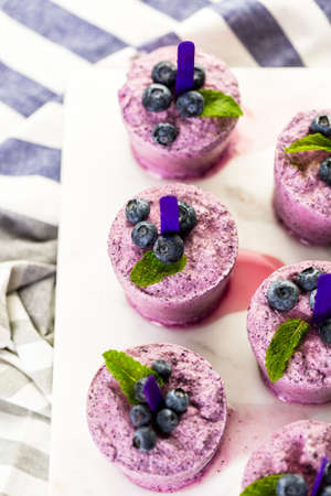 Homemade blueberry popsicles made in plastic cups.の写真素材