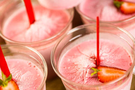 Homemade strawberry popsicles made in plastic cups.の写真素材