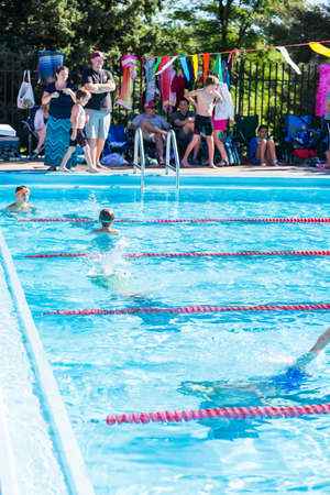 Denver, Colorado, USA-July 11, 2015. Kids swim meet in outdoor pool during the summer.のeditorial素材