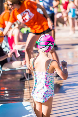 Denver, Colorado, USA-July 11, 2015. Kids swim meet in outdoor pool during the summer.のeditorial素材