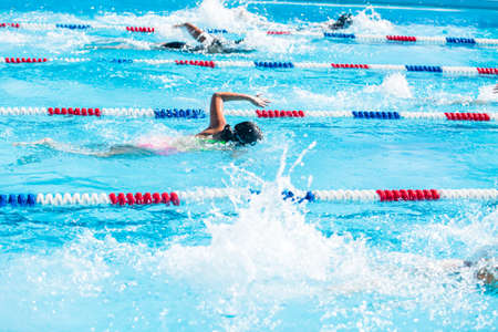Kids swim meet in outdoor pool during the summer.の写真素材