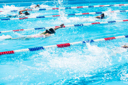 Kids swim meet in outdoor pool during the summer.の写真素材