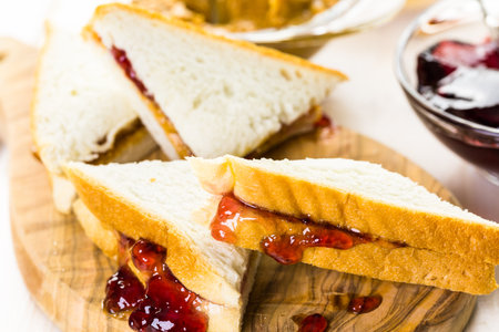 Homemade peanut butter and jelly sandwich on white bread.の写真素材
