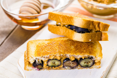Homemade peanut butter and blueberry sandwich on white bread.