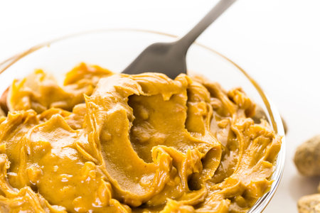 Extra chunky peanut butter on a white background.