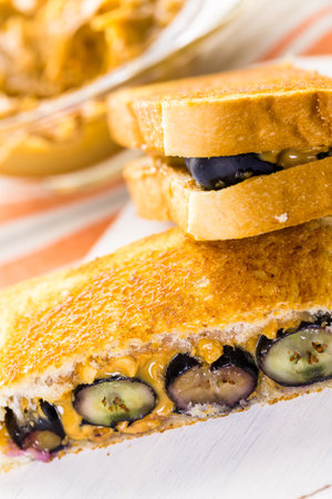Homemade peanut butter and blueberry sandwich on white bread.の写真素材