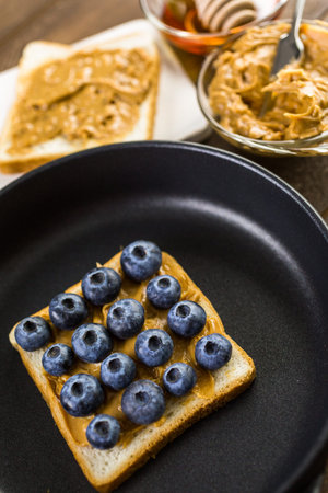 Homemade peanut butter and blueberry sandwich on white bread.