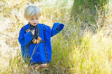 Russian children in traditional Russian costumes playing in the forest.