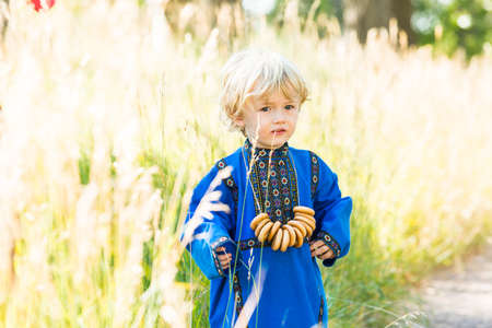 Russian children in traditional Russian costumes playing in the forest.の写真素材