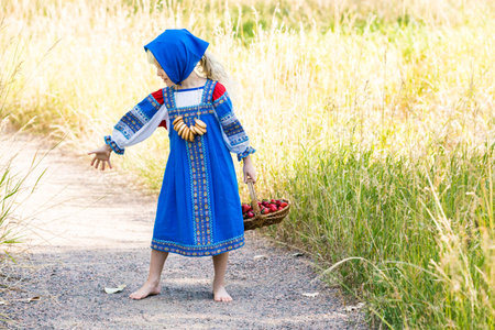 Russian children in traditional Russian costumes playing in the forest.