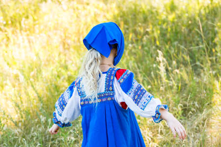 Russian children in traditional Russian costumes playing in the forest.の写真素材