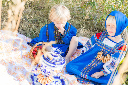 Russian children in traditional Russian costumes playing in the forest.