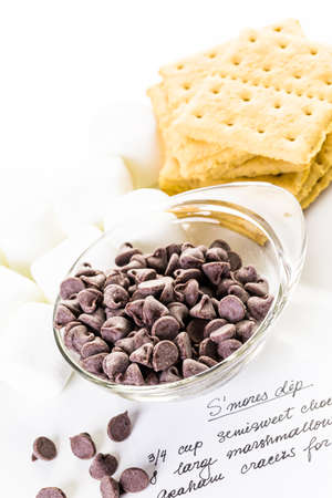 Ingredients smores dip prepared with large marshmallows in cast iron pan.の写真素材