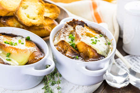 Homemade French onion soup with toasted baguette.の写真素材