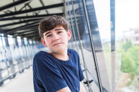Teenage boy at the lightrail station in urban area.の写真素材