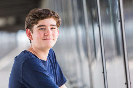 Teenage boy at the lightrail station in urban area.の写真素材
