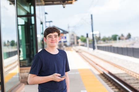 Teenage boy at the lightrail station in urban area.の写真素材