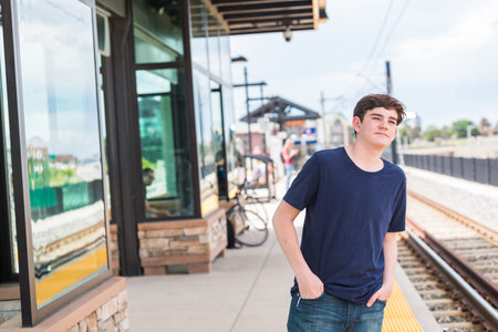 Teenage boy at the lightrail station in urban area.