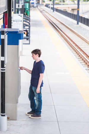 Teenage boy at the lightrail station in urban area.の写真素材