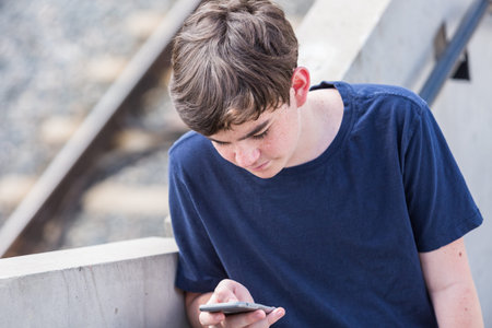 Teenage boy at the lightrail station in urban area.の写真素材