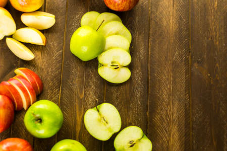 Variety of organic apples sliced on wood table.の写真素材
