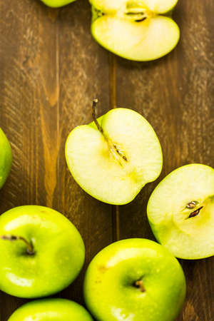 Variety of organic apples sliced on wood table.の写真素材