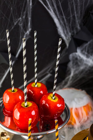 Table with colored candy apples and cake for Halloween party.の写真素材