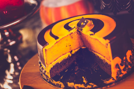 Table with colored candy apples and cake for Halloween party.