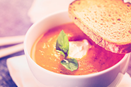 Roasted tomato soup cooked with organic heirloom tomatoes and served with grilled cheese sandwich.の写真素材