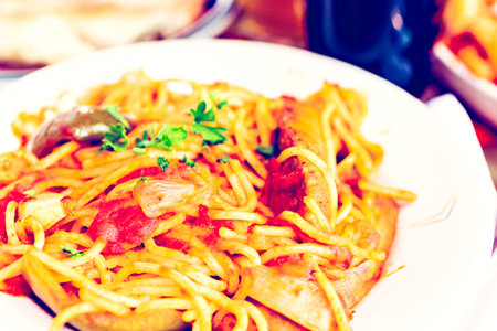 Fresh spaghetti with sausage peppers and onions in Italian restaurant.の写真素材
