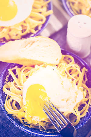 Fresh pasta pangrattato with crispy eggs on the table.の写真素材
