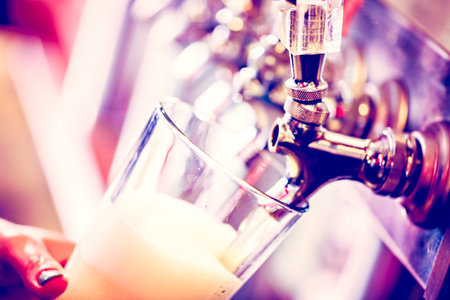 Bartender pouring draft beer in the bar.