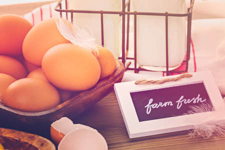 Fresh farm eggs, milk and butter on wood table.の写真素材