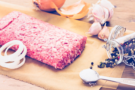 Ground pork on the table with other ingredients for recipe.